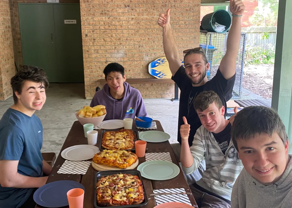 group picture from an eds change life skills program, eating the pizza they prepared earlier, practicing life skills